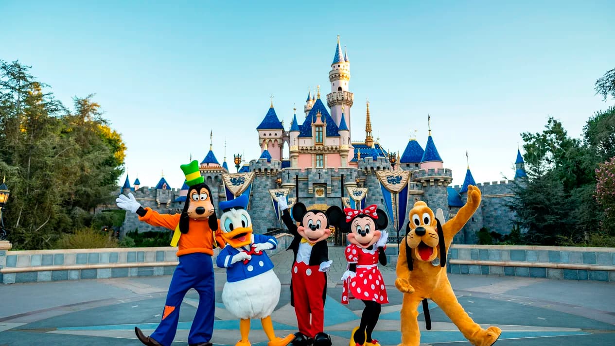 Mickey Mouse, Minnie Mouse, Pato Donald, Goofy y Pluto frente al castillo de Disney en Disneyland California